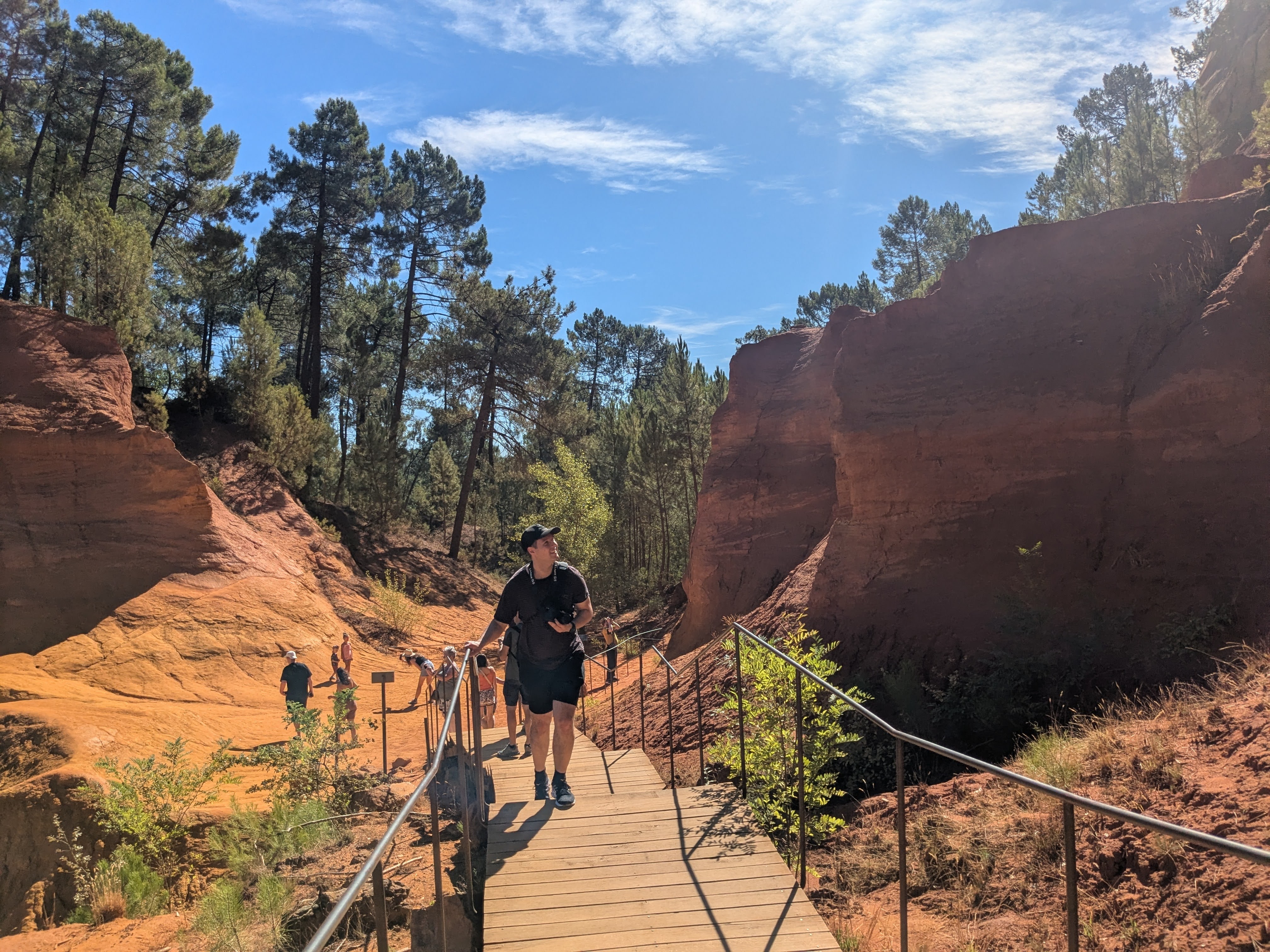 Therry walking near the ocher cliffs in Roussillon, looking up.